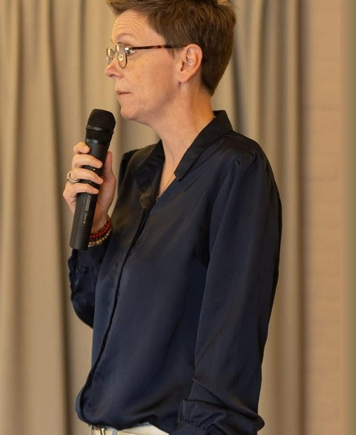 Saskia Ebbers spreekt met een microfoon tijdens een lezing
